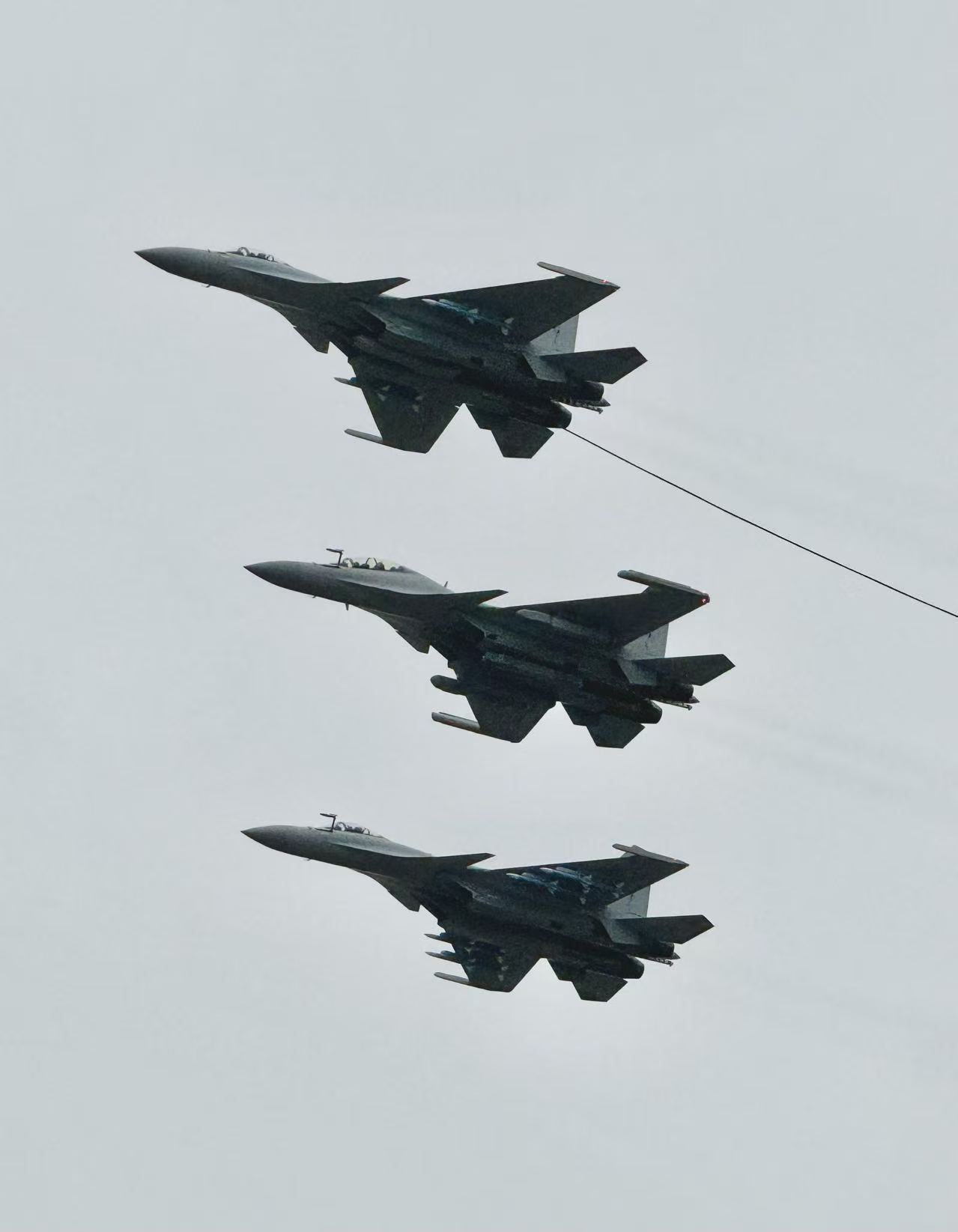 Three aircraft flying in formation against an overcast sky